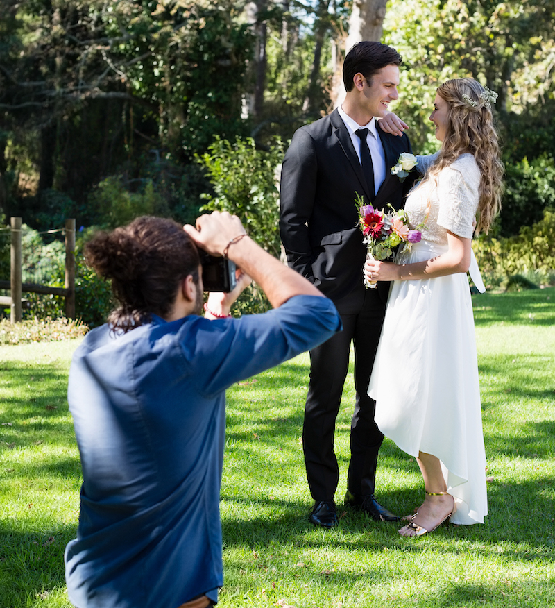 Photographer taking photo of newly married couple