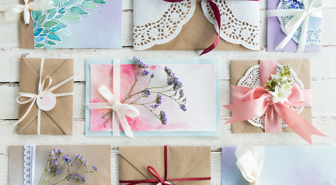 top view of collection of envelopes or invitations on white wooden tabletop, wedding invitation card